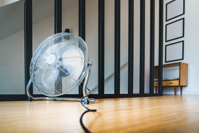 Brasseur d'air de séchage dirigé contre un mur après un dégât des eaux